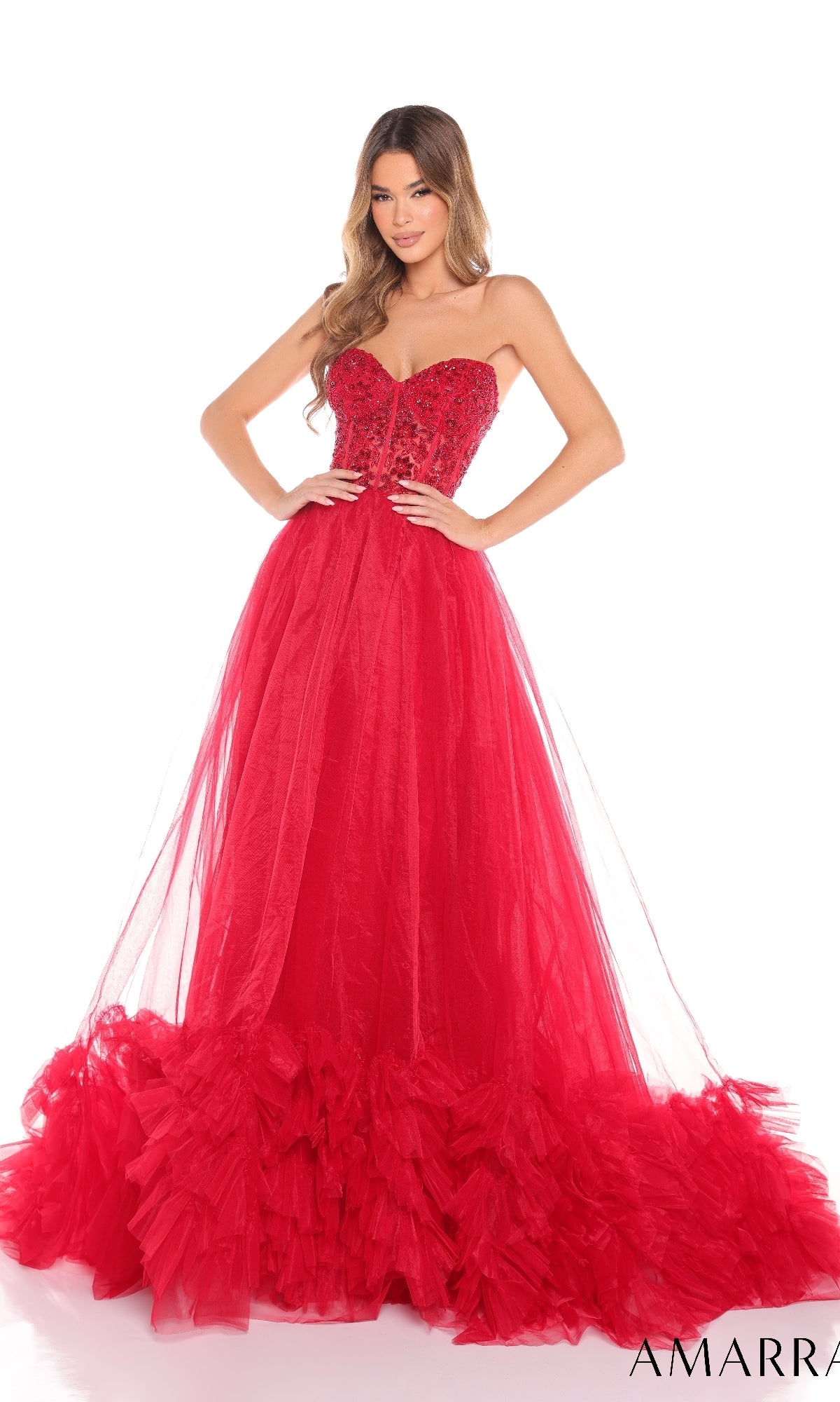 A woman wears the Amarra 88339 long prom dress, featuring a strapless corset bodice, shimmering details, and a voluminous tulle floor-length skirt with dramatic ruffled layers at the hem.